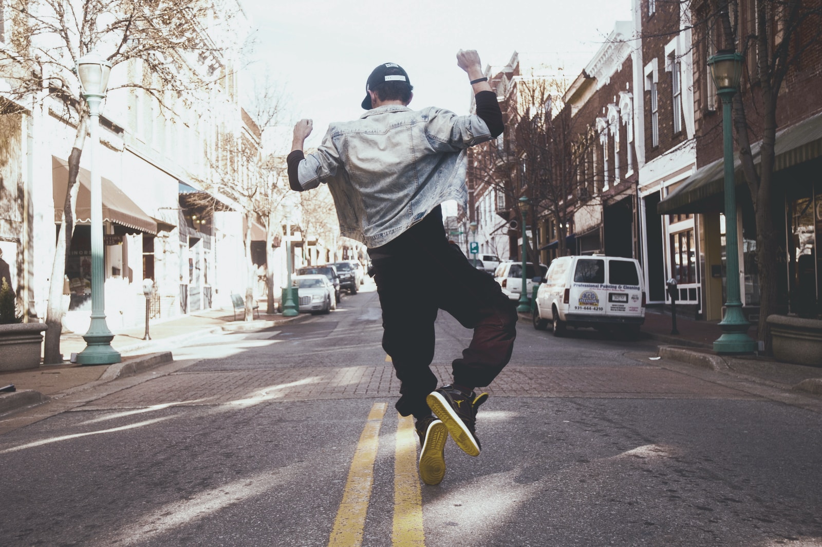 headphonik - man jumping on the middle of the street during daytime